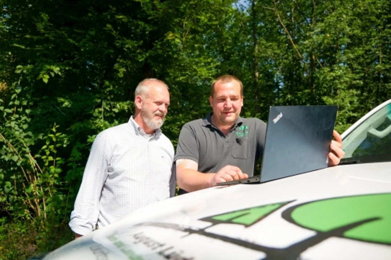 Zwei Ansprechpartner von August Lüdemann mit einem Laptop im Außeneinsatz