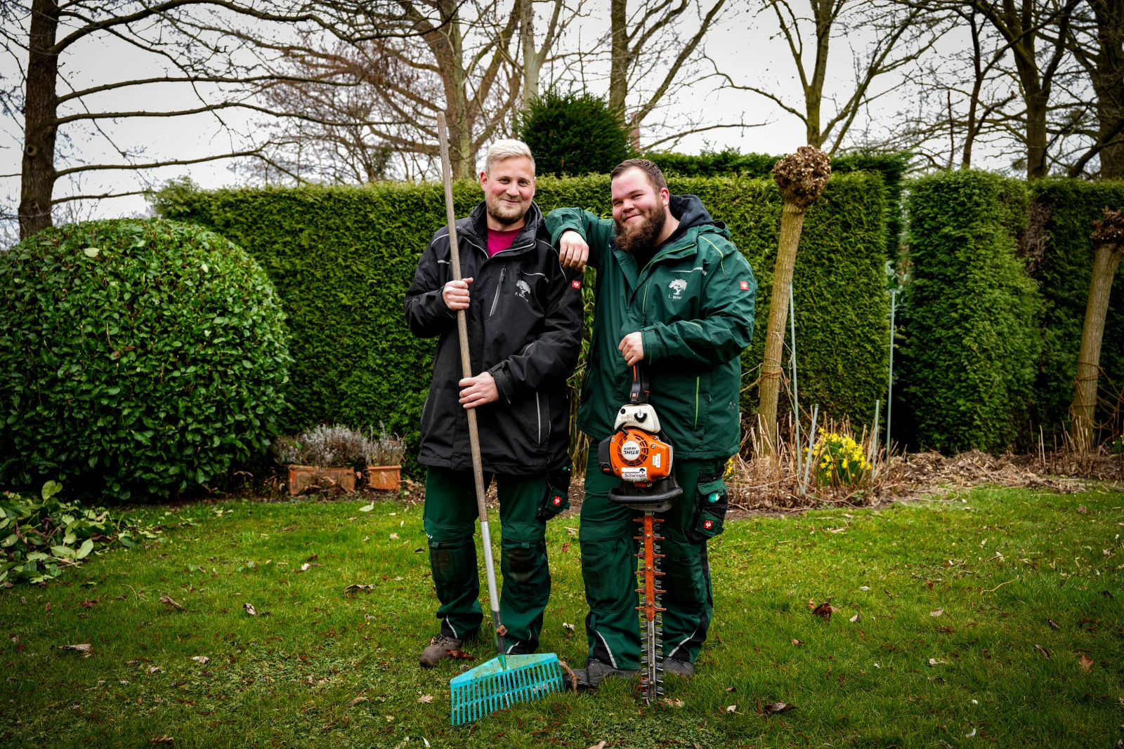 Zwei Mitarbeiter von Gartengestaltung Schwingel mit Gartenwerkzeugen